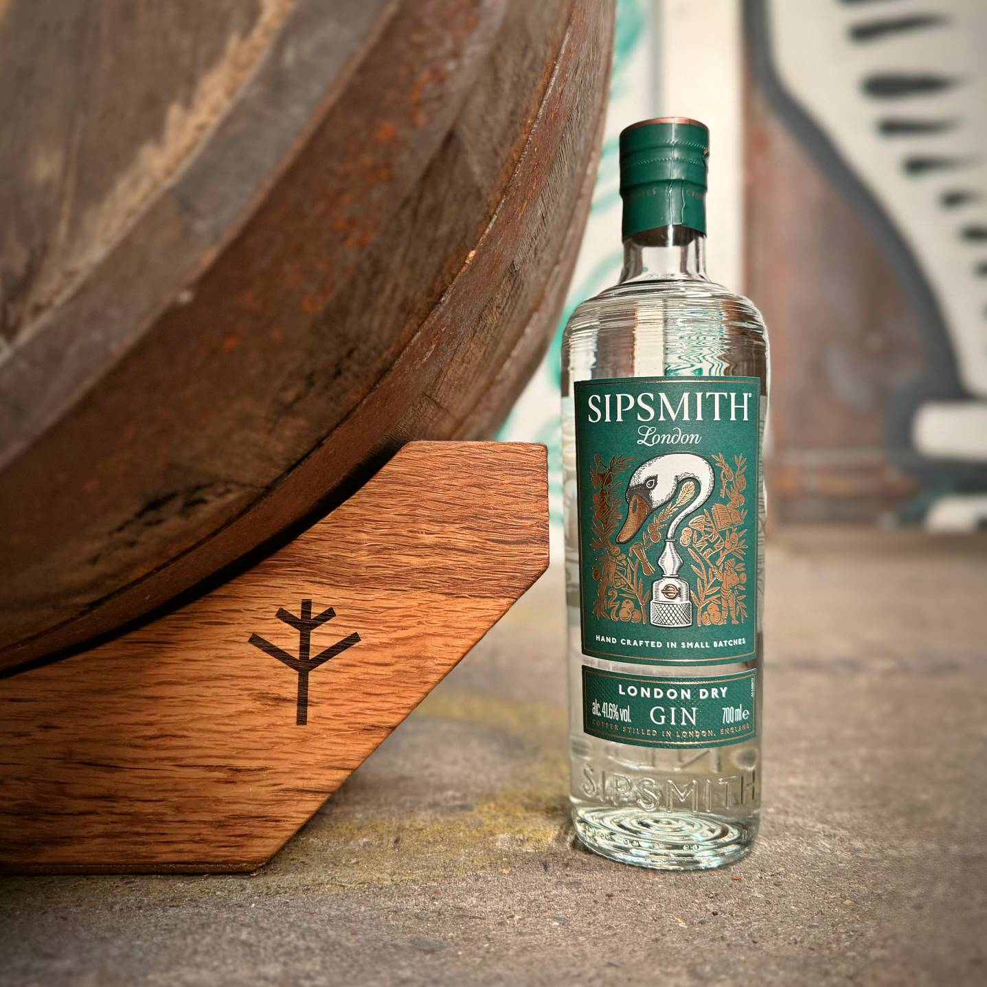 Oak stands support a barrel next to a bottle of Sipsmith gin