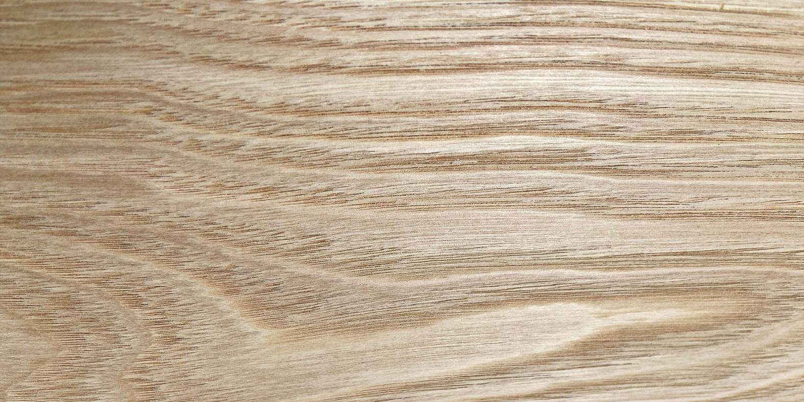 Close-up of a sweet chestnut wood board surface with a light brown color and visible grain pattern.