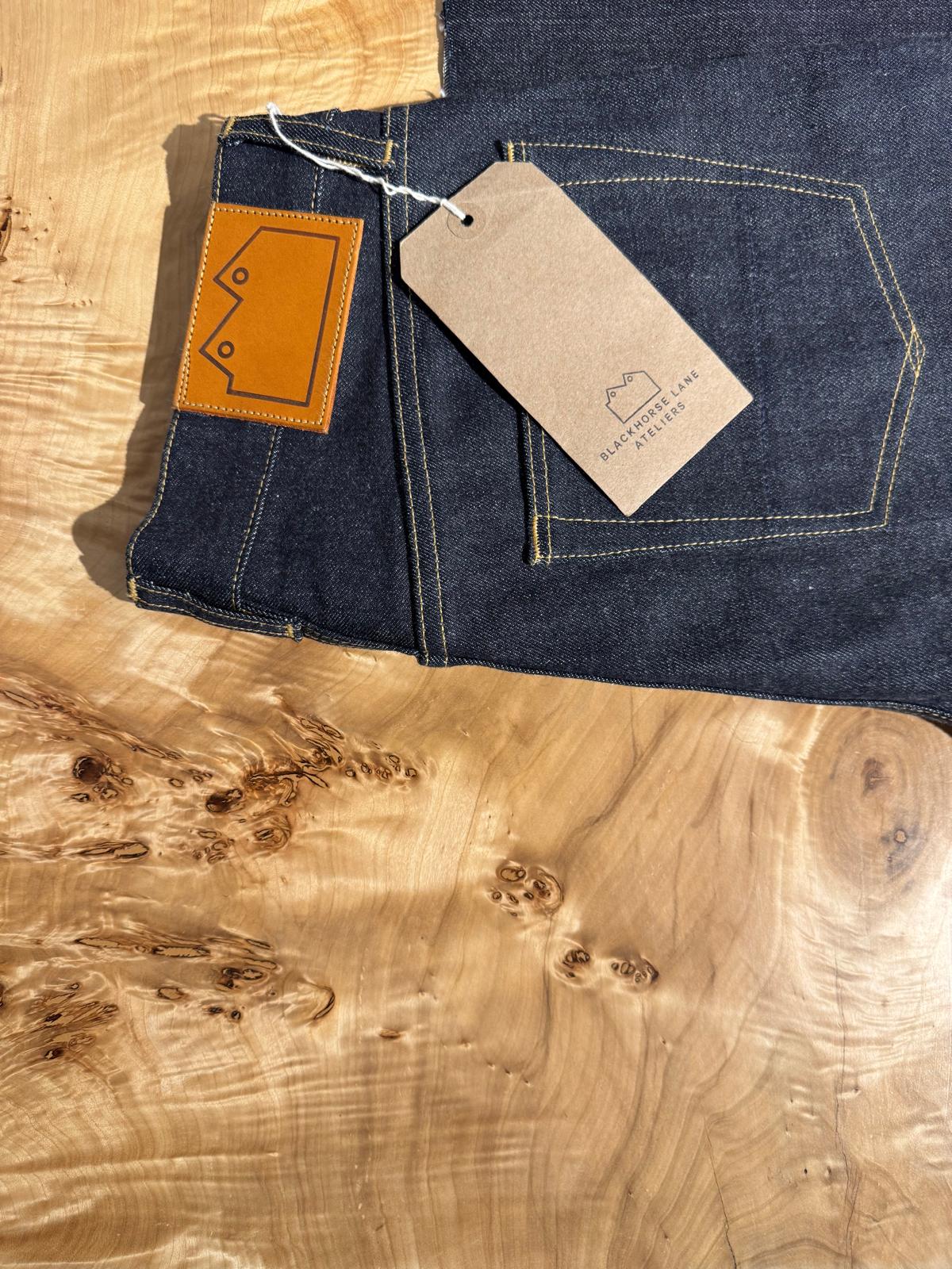 A pair of jeans on a richly grained wooden slab table